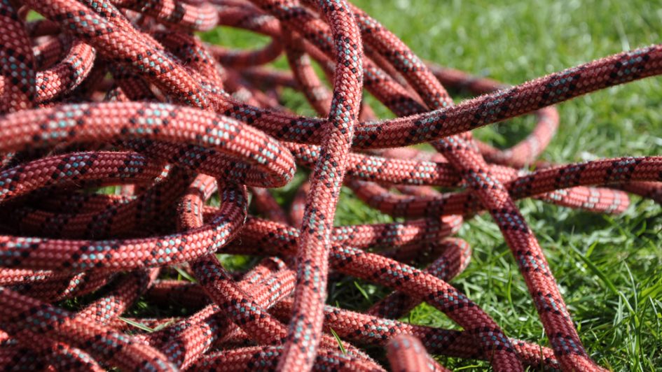 Red striped climbing rope on grass