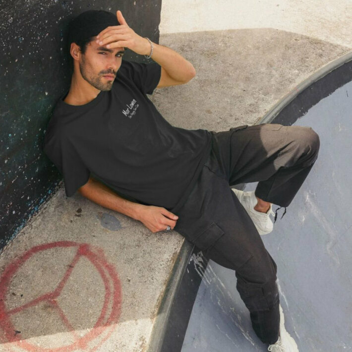 A front view of the Reverse Happy Sea Club Tee in black as worn by a model